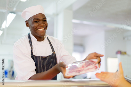 african butcher selling beef to customer