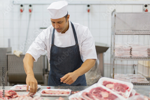 Obraz na płótnie mid age butcher packing meat pieces