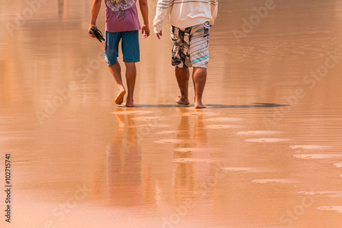Two Men Walking on the Wet Sand