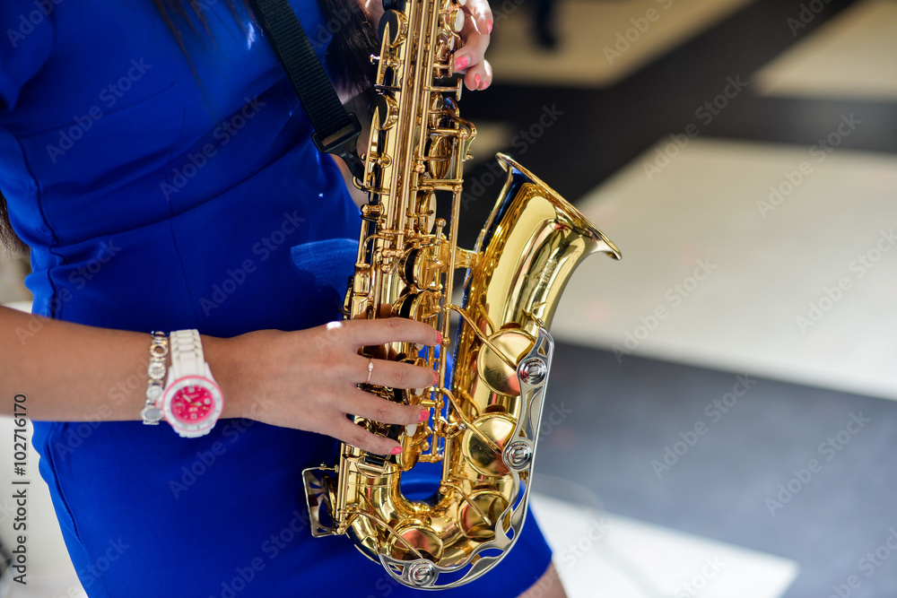 Obraz premium Saxophonist woman in blue dress