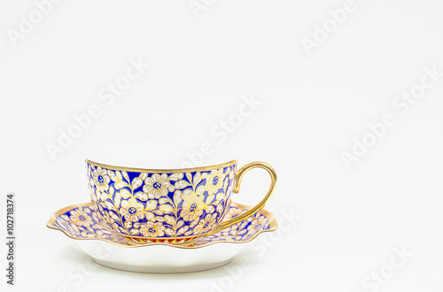 Antique Thai ceramic coffee cup with saucer on white background