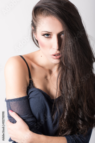 Brunette woman with blue eyes wearing shirt and blue jeans