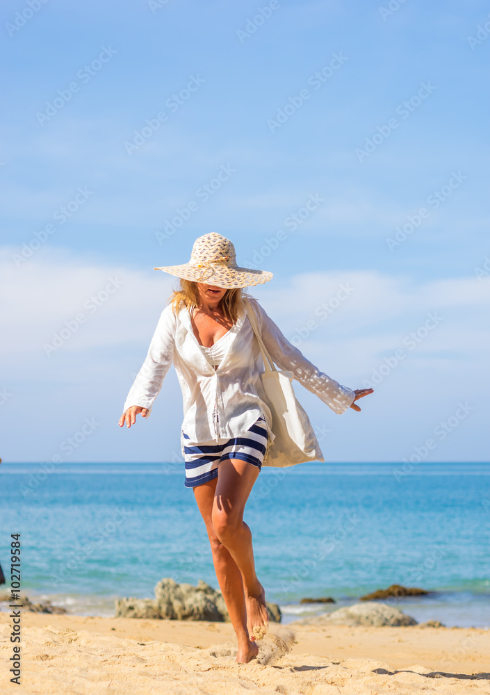 woman enjoying perfect sunny day walking on the beach woman enjoying perfect sunny day walking on the beach
