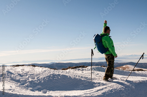 Cheerful man hiker on top of mountain