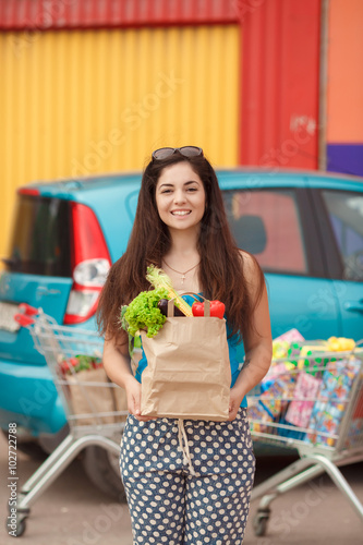 Woman with vegatables at shopping mall girl at super market hold food photo