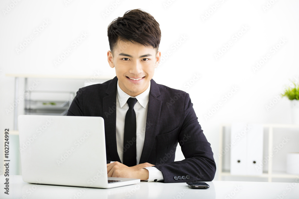 young smiling businessman working in office young smiling businessman working in office