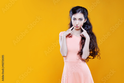 Fashion asian young girl. Portrait on yellow background. 