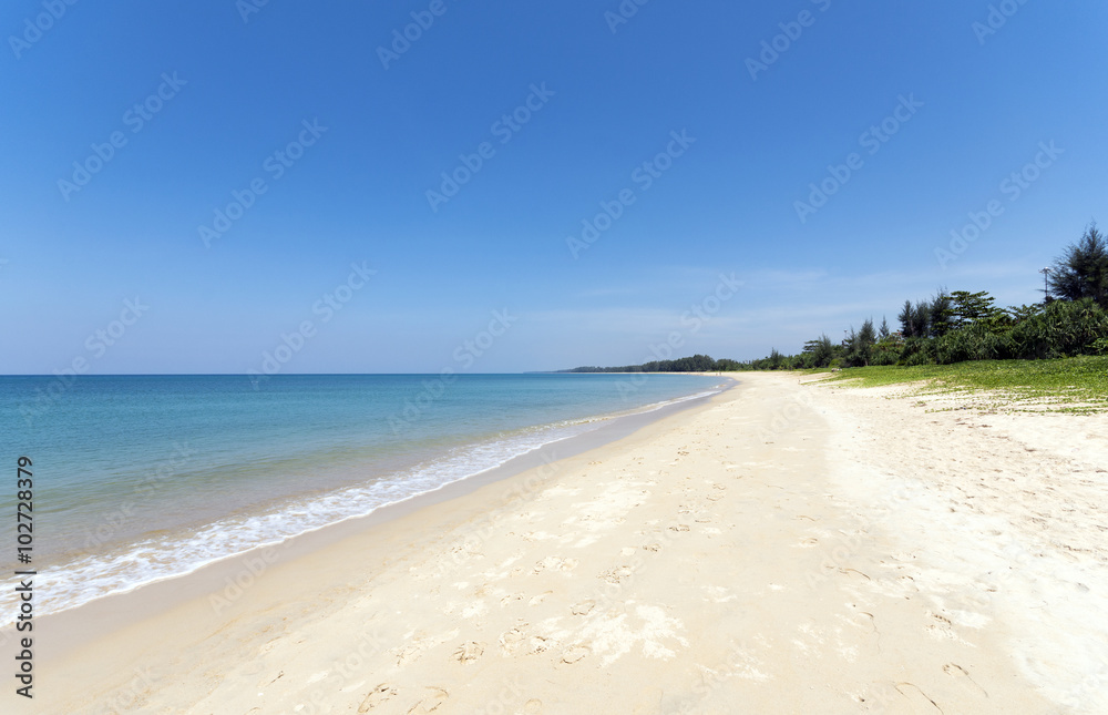 Beach, blue sea and white sands of Mai Khao Beach, Phuket, Thailand.