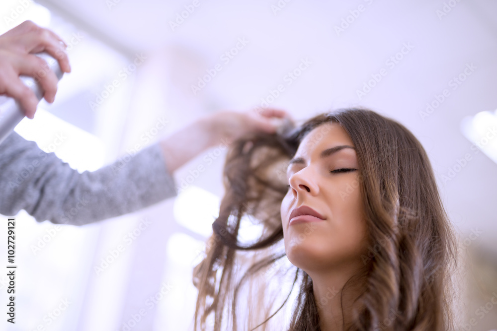 Fototapeta premium Hairdresser spraying his customer's hair
