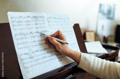 Writing notes in between the lines on  sheet music