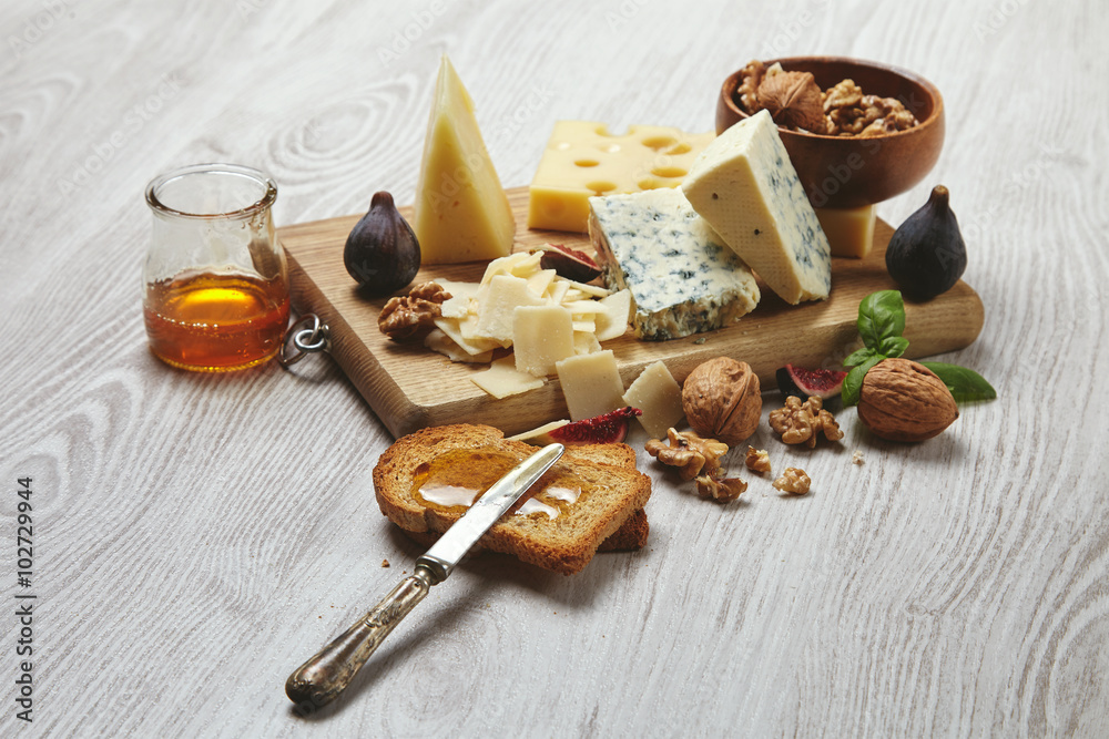 Set four cheeses served with figs and nuts side view Set four cheeses served with figs and nuts side view