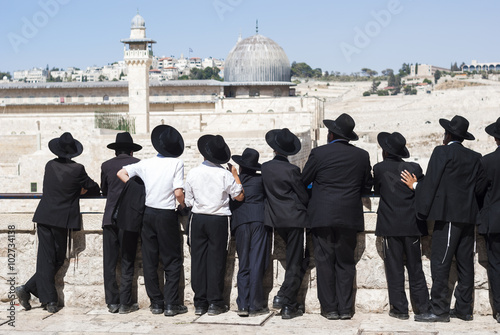 A group of Ultra Orthodox Jews, yeshiva students standing in front of the Western Wall, Temple Mount and Al Aqsa mosque. Temple Jerusalem, the Old city of Jerusalem, Israel. photo