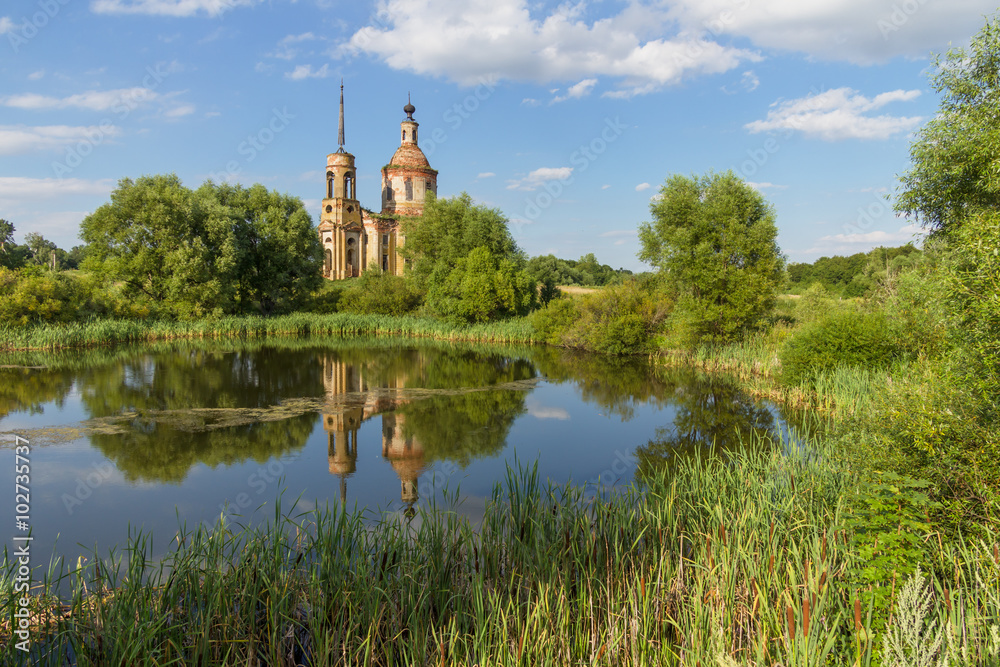 Summer landscape with an old ruined church on the bank of the pond. Church of the Ascension in the village Skorodnoye in the Lipetsk region Summer landscape with an old ruined church on the bank of the pond. Church of the Ascension in the village Skorodnoye in the Lipetsk region