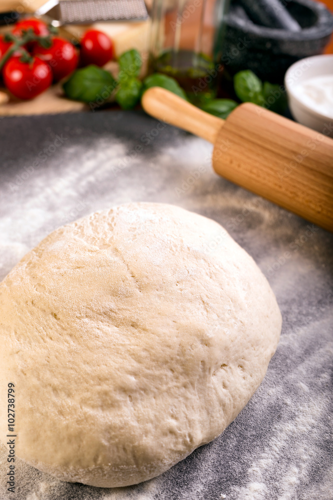 Rolling pizza dough with wooden roller Rolling pizza dough with wooden roller