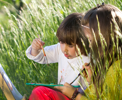 Two little girls painting in nature photo