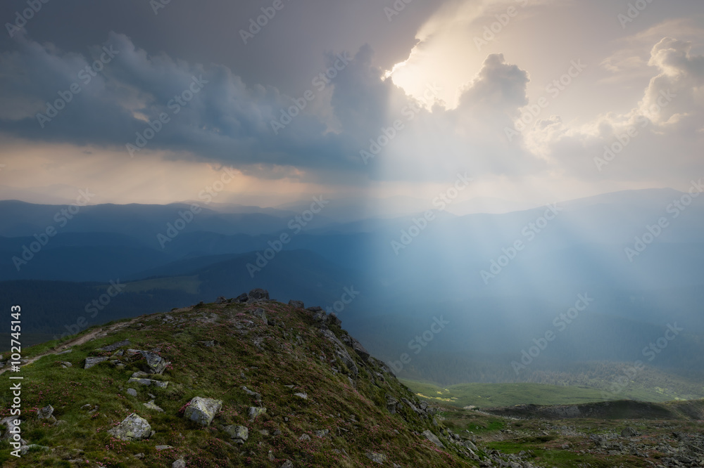 Carpathian Mountains. The rays breaking through the clouds illuminating the ground Carpathian Mountains. The rays breaking through the clouds illuminating the ground