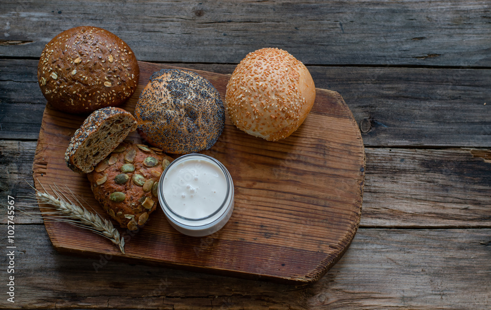 Bread rolls in assortment and yogurt on a wooden table Bread rolls in assortment and yogurt on a wooden table