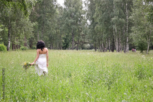 Beauty girl in a meadow picking flowers  spring mood