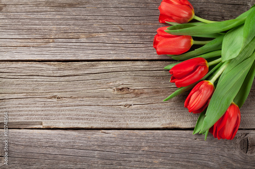 Fototapeta Naklejka Na Ścianę i Meble -  Valentine's day red tulips over wood