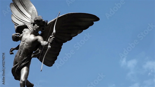 The Statue of Eros, a prominent landmark in Piccadilly Circus, London, UK; time lapse clouds with copy space.