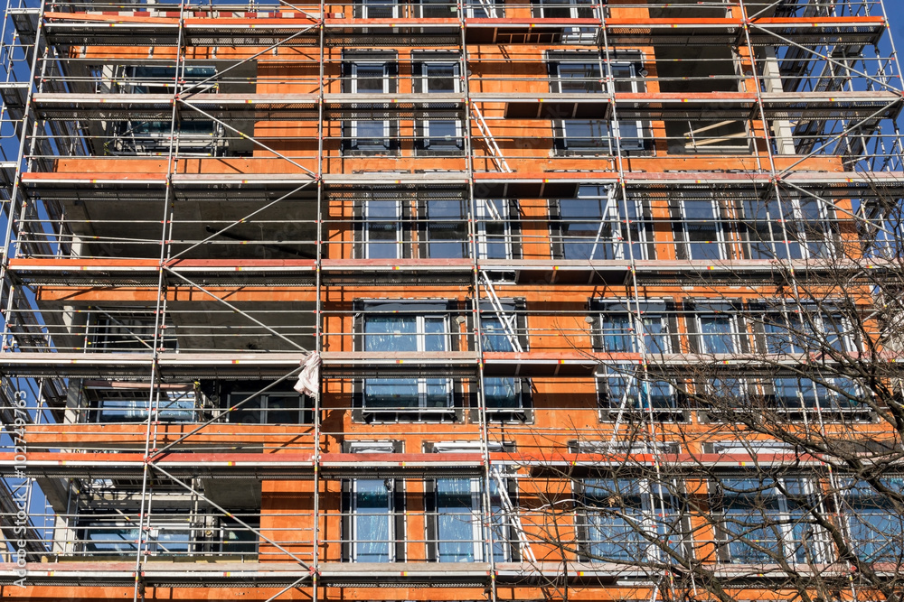 Building construction site with scaffolding. Walls from red brick Building construction site with scaffolding. Walls from red brick