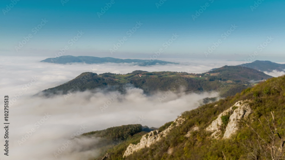 Fog around a mountain / Timelapse video of an autumn or spring morning in the mountain area with fog or mist moving 