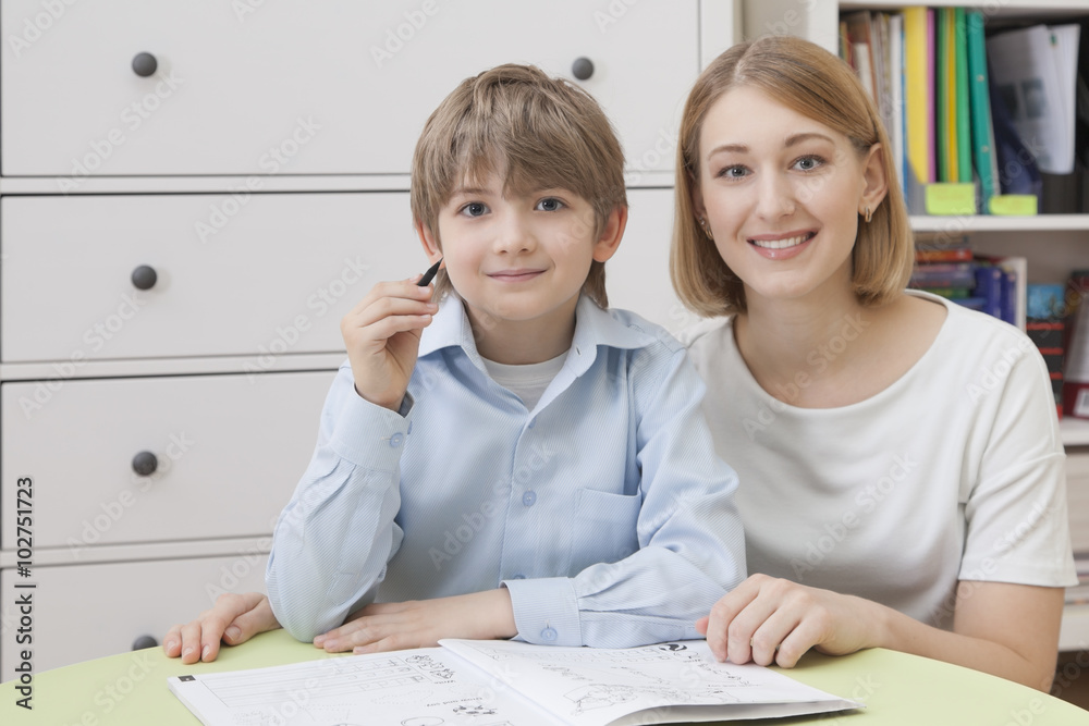 Pretty young teacher with a pupil sitting at a desk Pretty young teacher with a pupil sitting at a desk
