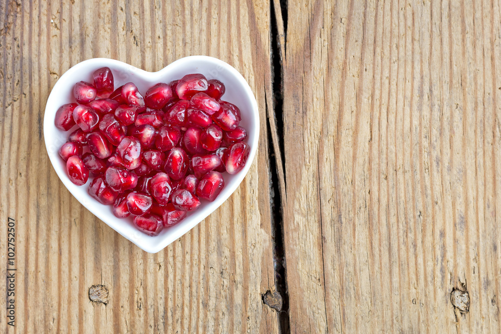 Pomegranate seeds in heart shaped bowl Pomegranate seeds in heart shaped bowl