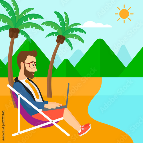 Businessman sitting in chaise lounge with laptop.