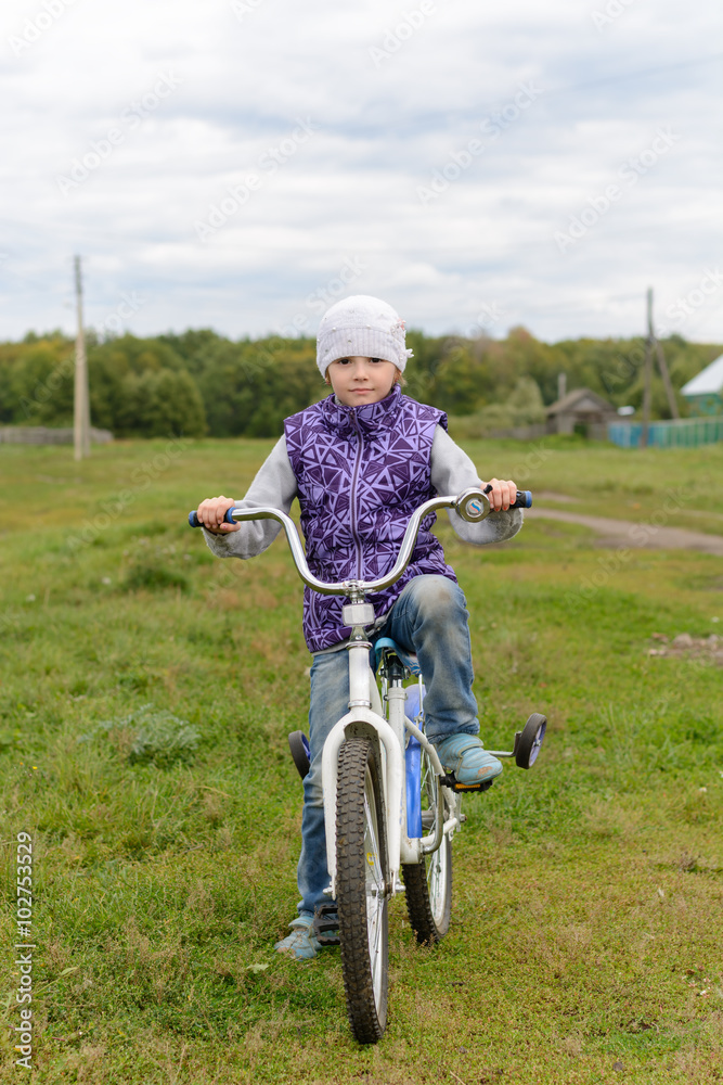 The girl in the purple vest rides his bike The girl in the purple vest rides his bike