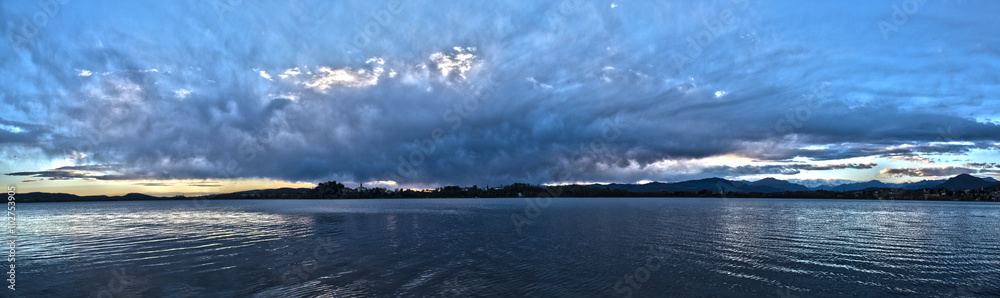 Landscape on the Varese lake with storm cloudy sky at the sunset