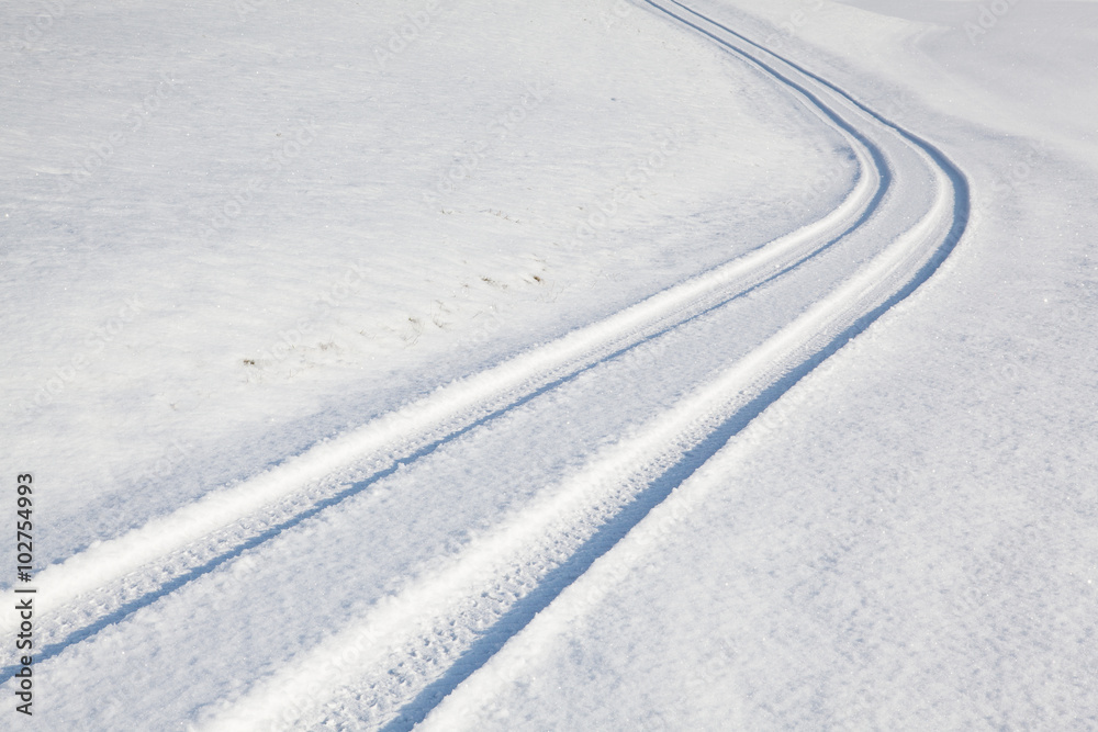 Car tire track on winter road