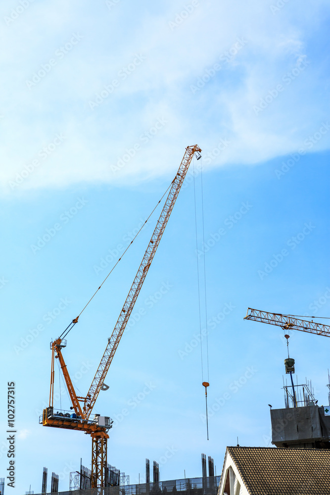 Building crane and construction site under blue sky