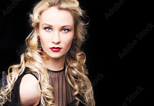 Beautiful fashion model girl with blond hair. Portrait of glamour woman with bright makeup isolated on black background.