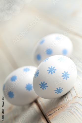 Three Easter eggs on wooden background