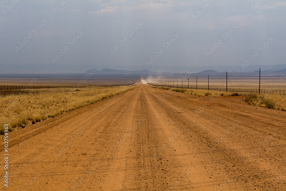 Naklejka premium red sand gravel road with car