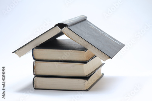 House made with books piled on white background photo