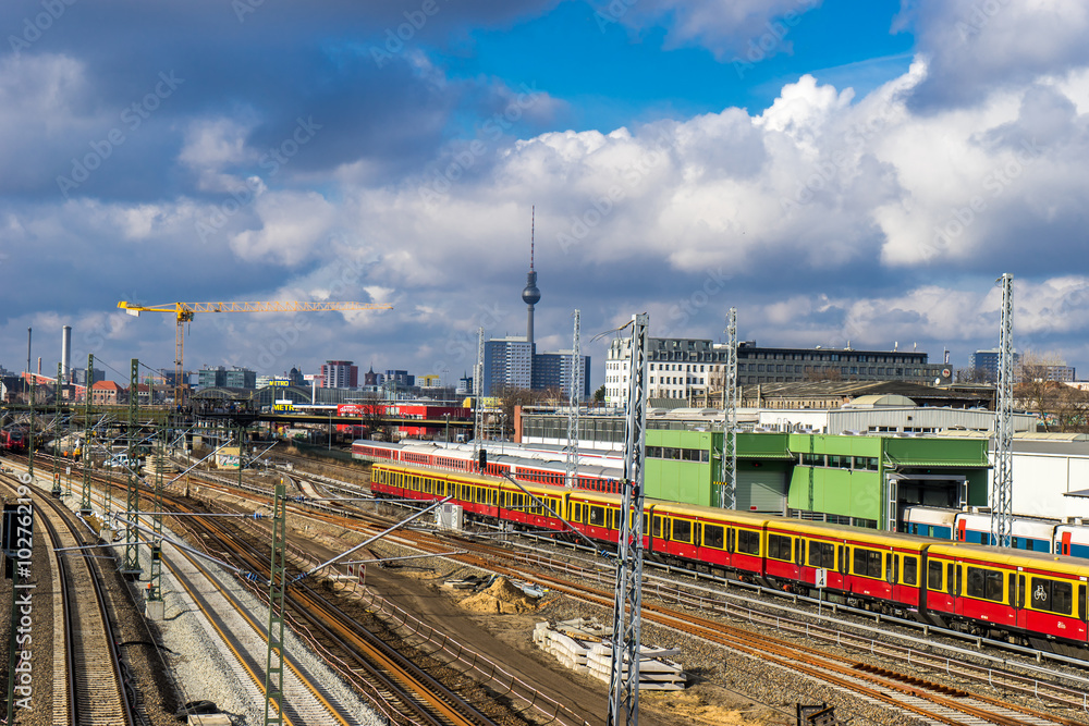 Fototapeta premium railway tracks going through the city center of Berlin, with cityscape in the background
