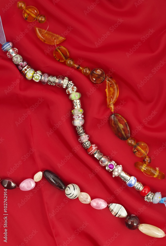 Strings of beads on red textile background Strings of beads on red textile background