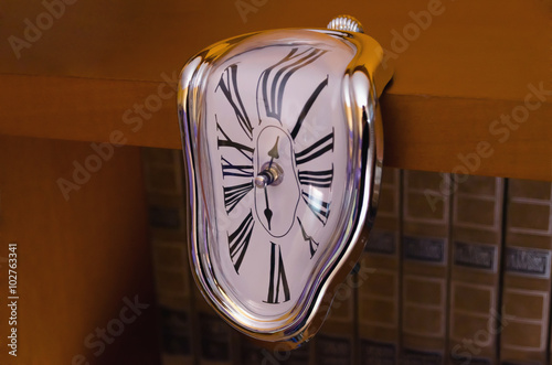 Surreal liquefied clock flowing down table