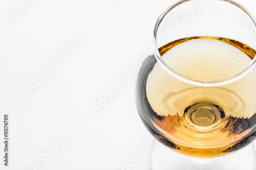 The cognac glass with golden brown alcohol inside.