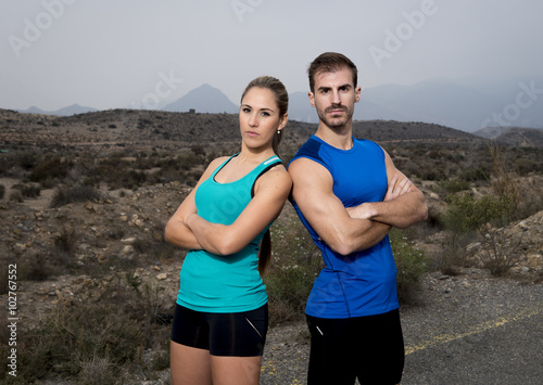 young sport couple posing shoulder to shoulder looking cool and defiant attitude