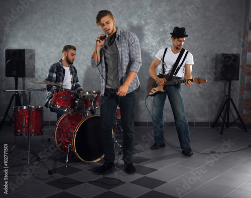 Musicians playing musical instruments and singing songs in a studio photo