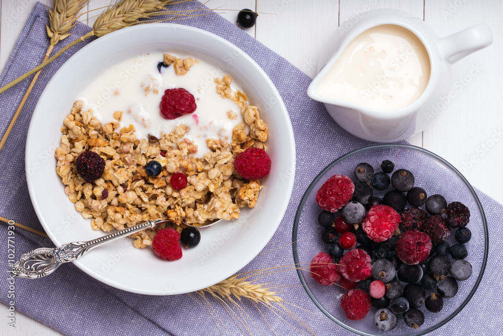 Muesli with yogurt and fresh berries in a ceramic bowl, top view Muesli with yogurt and fresh berries in a ceramic bowl, top view