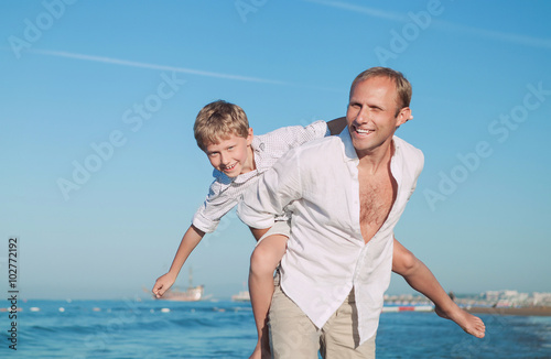 Father with son play together on the sea side