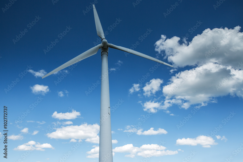 Wind energy turbine and fluffy clouds in the sky Wind energy turbine and fluffy clouds in the sky