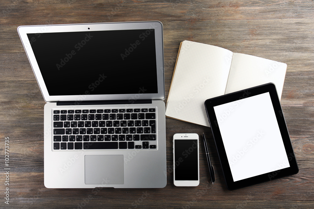 Modern laptop, tablet, mobile phone and notebook on the table Modern laptop, tablet, mobile phone and notebook on the table