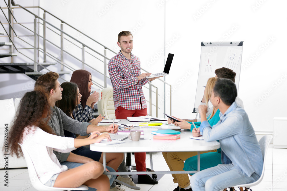 Young man making a presentation with laptop in the office Young man making a presentation with laptop in the office