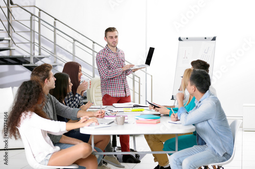 Young man making a presentation with laptop in the office