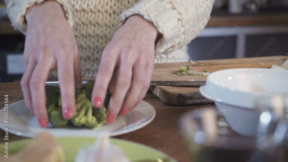 young woman putting broccoli on the plate, slow motion young woman putting broccoli on the plate, slow motion